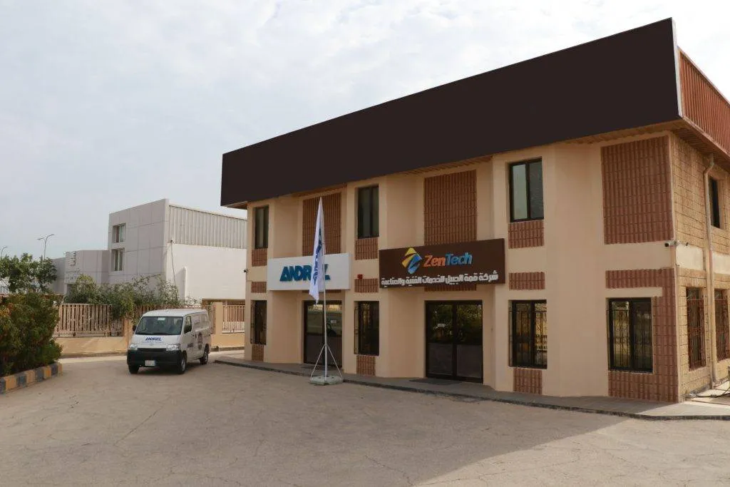 A two-story building with company signage and a van parked in front.